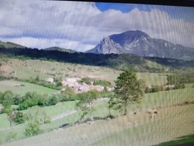 a view of a field with a mountain in the background at Maison de village avec jardin in Saint-Louis-et-Parahou