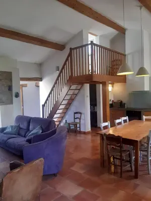 a living room with a blue couch and a wooden table at Le Pigeonnier au dessus du lac in Caraman