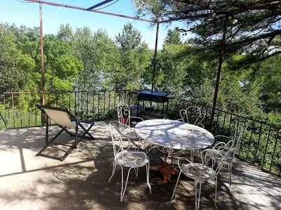 a table and chairs sitting on a patio at Le Pigeonnier au dessus du lac in Caraman
