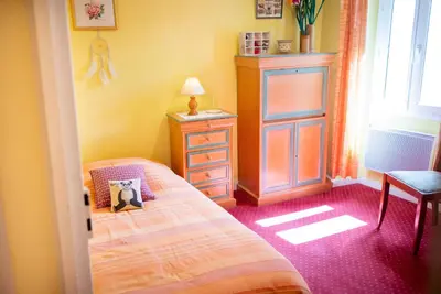 a small bedroom with a bed and a dresser at La Maison Bleue, nid chaleureux en bord de rivière in Rennes-les-Bains