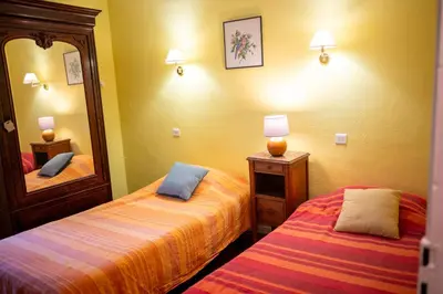 a hotel room with two beds and a mirror at La Maison Bleue, nid chaleureux en bord de rivière in Rennes-les-Bains