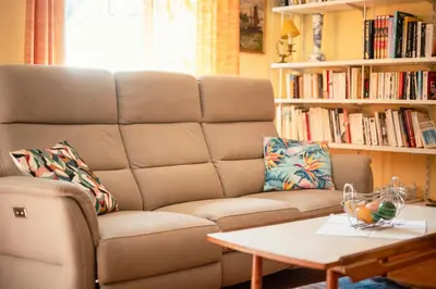 a living room with a couch and a coffee table at La Maison Bleue, nid chaleureux en bord de rivière in Rennes-les-Bains