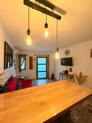 a living room with a wooden table and lights at Charmante maison de village in Peyriac-de-Mer