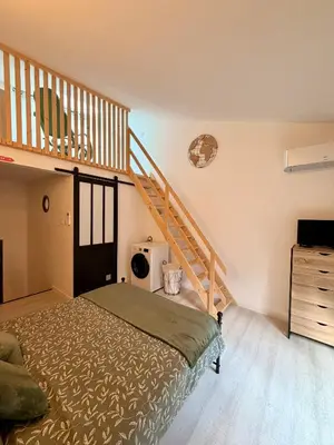 a bedroom with a bed and a staircase at Charmante maison de village in Peyriac-de-Mer