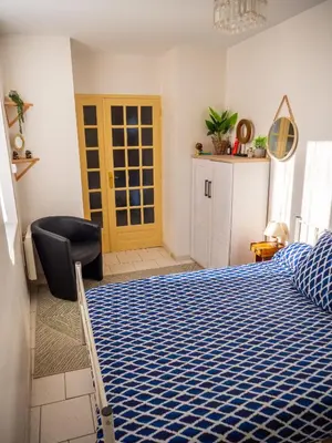 a bedroom with a bed and a chair in it at Maison Chevalier in Narbonne
