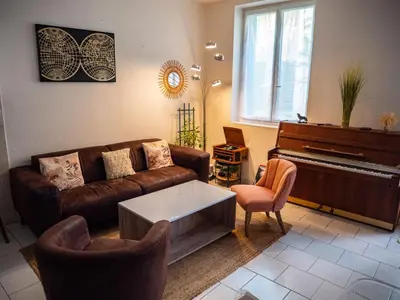 a living room with a couch and a piano at Maison Chevalier in Narbonne