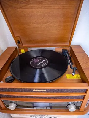a record player with a vinyl record in a wooden box at Maison Chevalier in Narbonne