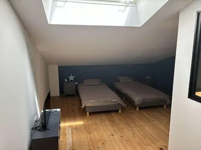 a bedroom with two beds and a skylight at Jolie villa avec piscine in Palaja