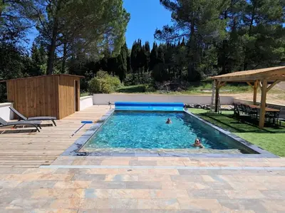 two people are swimming in a swimming pool at Jolie villa avec piscine in Palaja