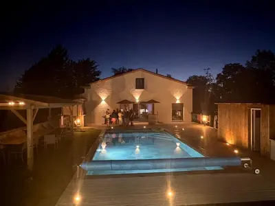 a swimming pool in front of a house at night at Jolie villa avec piscine in Palaja