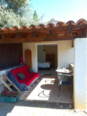 a patio with a bed and a table on a patio at Gite de l'Etang proche des Grands Buffets in Narbonne