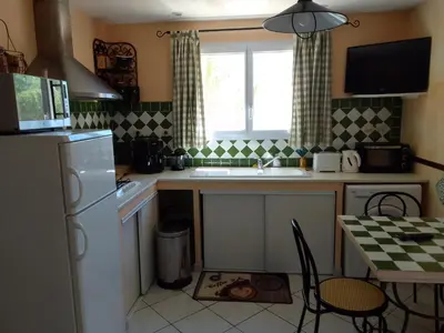 a kitchen with a sink and a table with chairs at Gite de l'Etang proche des Grands Buffets in Narbonne