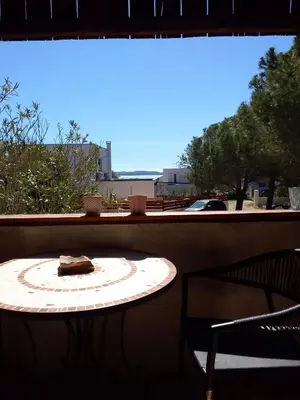 a table on a balcony with a plate of food on it at Gite de l'Etang proche des Grands Buffets in Narbonne