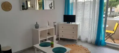 a living room with a television and a table at Très beau Studio Cosy à 500m de la Plage in Gruissan