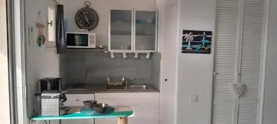 a kitchen with a sink and a clock on the wall at Très beau Studio Cosy à 500m de la Plage in Gruissan