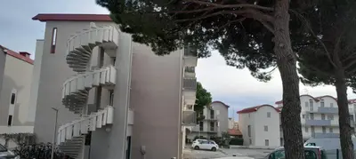 a white building with spiral stairs on the side of it at Très beau Studio Cosy à 500m de la Plage in Gruissan