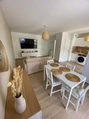 a kitchen and living room with a white table and chairs at Appartement Carcassonne résidence capucins in Carcassonne