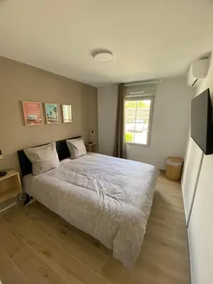 a bedroom with a large bed and a television at Appartement Carcassonne résidence capucins in Carcassonne