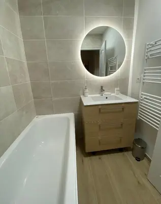 a bathroom with a tub and a sink and a mirror at Appartement Carcassonne résidence capucins in Carcassonne
