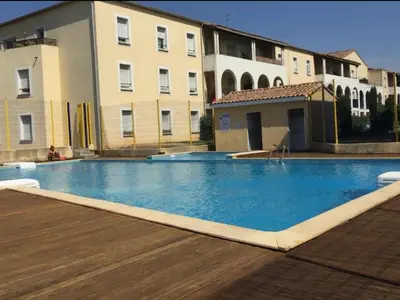 a large swimming pool in front of a building at Appartement Carcassonne résidence capucins in Carcassonne