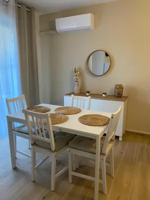 a white dining room table with chairs and a mirror at Appartement Carcassonne résidence capucins in Carcassonne