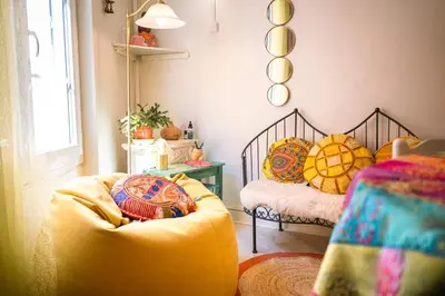 a living room with a yellow couch and a bed at Petite Maison de Resource avec Cuisine in Rennes-les-Bains