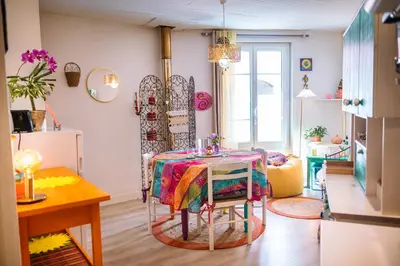 a living room with a table and a kitchen at Petite Maison de Resource avec Cuisine in Rennes-les-Bains