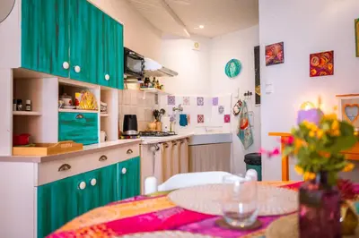 a kitchen with green cabinets and a dining table at Petite Maison de Resource avec Cuisine in Rennes-les-Bains