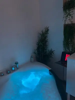 a bath tub filled with blue water in a room at Le Somptueux, Cosy / Balnéo in Carcassonne