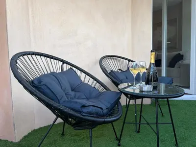 two chairs with blue pillows sitting next to a table at Le Somptueux, Cosy / Balnéo in Carcassonne