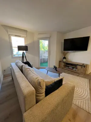 a living room with a couch and a flat screen tv at Le Somptueux, Cosy / Balnéo in Carcassonne