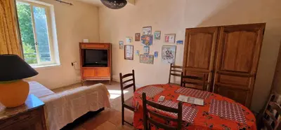 a living room with a table and a television at Domaine de La Pierre Chaude in Portel-des-Corbières