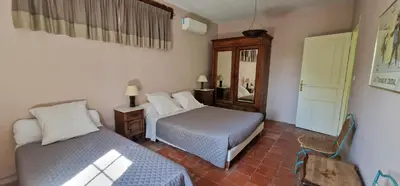 a bedroom with two beds and a mirror at Domaine de La Pierre Chaude in Portel-des-Corbières