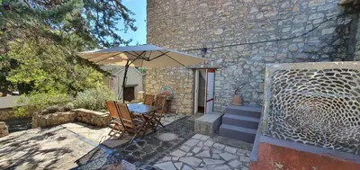a patio with a table and an umbrella at Domaine de La Pierre Chaude in Portel-des-Corbières