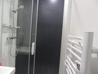 a shower with a glass door in a bathroom at Cottage du Lac in Olonzac