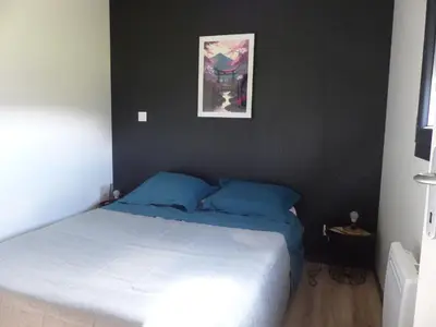 a bedroom with a bed and a picture on the wall at Cottage du Lac in Olonzac