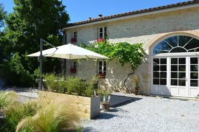 a house with an umbrella in front of it at Domaine du Léou in Fiac