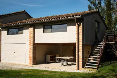 a house with a garage and a table on a patio at Domaine du Léou in Fiac