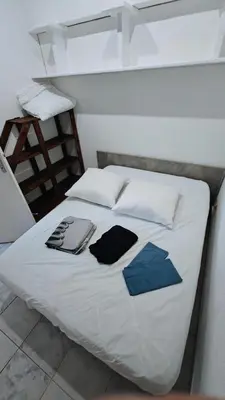 a bed with white sheets and blue pillows on it at pavillon 45m2, 2 Chambres, 1 salon cuisine, 1sdb in Gruissan