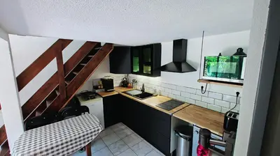 a small kitchen with black cabinets and a sink at pavillon 45m2, 2 Chambres, 1 salon cuisine, 1sdb in Gruissan