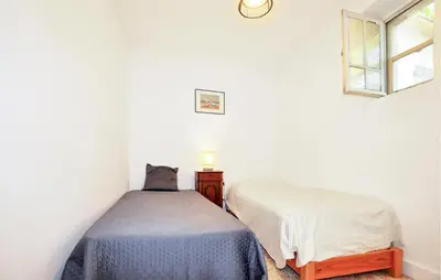 a bedroom with two beds and a window at Nice Home In Bizanet With Kitchen in Bizanet