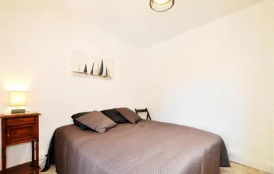 a bedroom with a bed and a dresser with a lamp at Nice Home In Bizanet With Kitchen in Bizanet