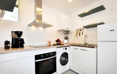 a white kitchen with a washer and dryer at Nice Home In Bizanet With Kitchen in Bizanet