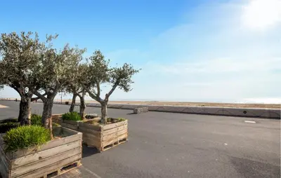 a parking lot next to the beach with trees at Nice Home In Bizanet With Kitchen in Bizanet