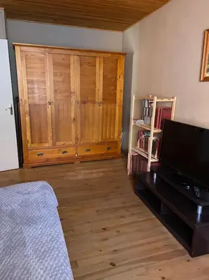 a living room with a television and wooden cabinets at Charmante maison à la montagne in Belcaire