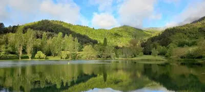 a reflection of a mountain in a lake at Charmante maison à la montagne in Belcaire