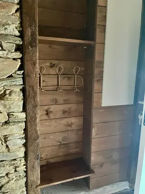 a wooden closet in a house with a stone wall at Parenthèse en Forêt - Gîte Hautbois, Sidobre in Le Bez