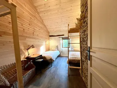 a room with a bed and a desk in a cabin at Parenthèse en Forêt - Gîte Hautbois, Sidobre in Le Bez