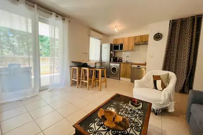 a living room with a couch and a table at Le Rimini Terrasse Wifi Parking privé in Narbonne