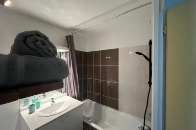 a bathroom with a sink and a bath tub and a sink at Le Rimini Terrasse Wifi Parking privé in Narbonne